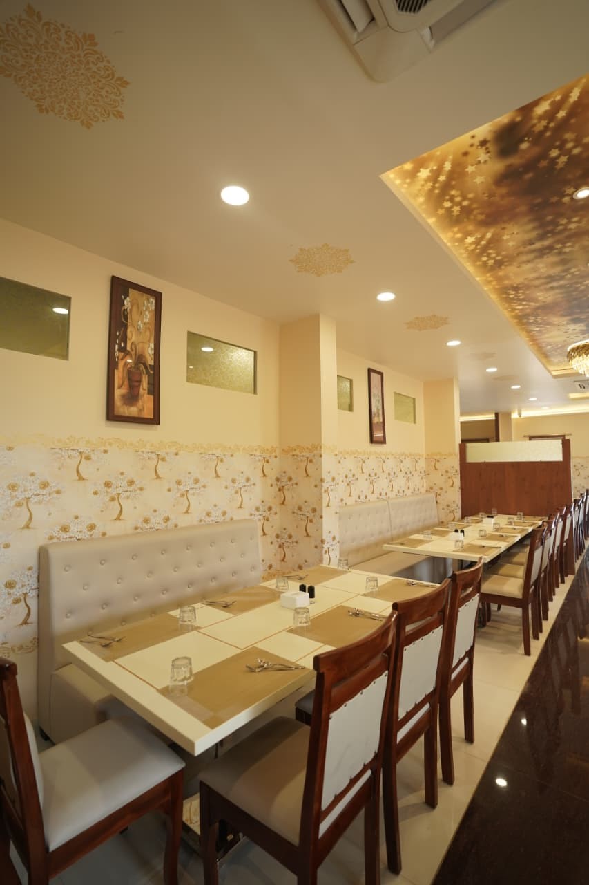 Long table set beside gold tree wallpaper