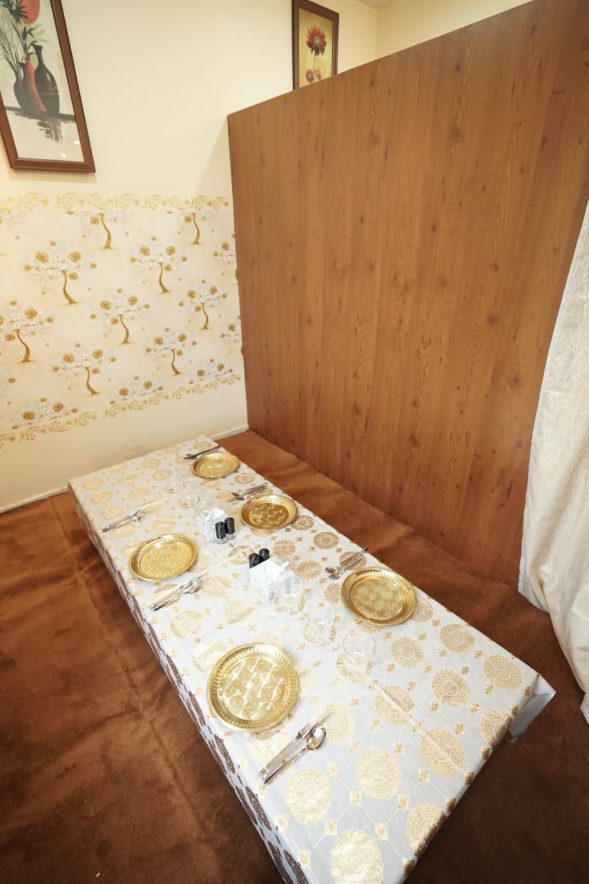 Low table dressed with brass plates for a shared meal