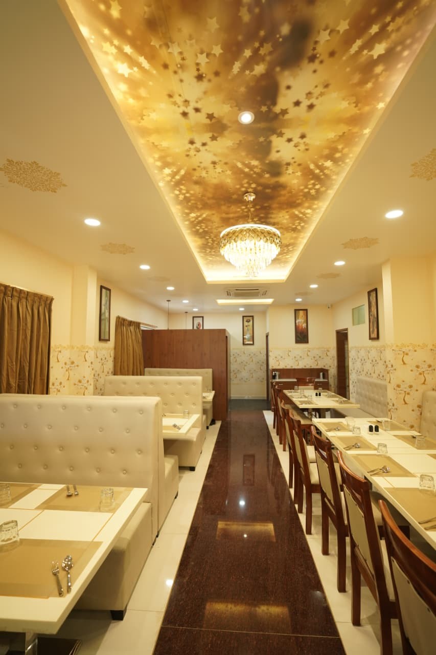 Main dining hall under a glowing gold star ceiling and crystal chandelier